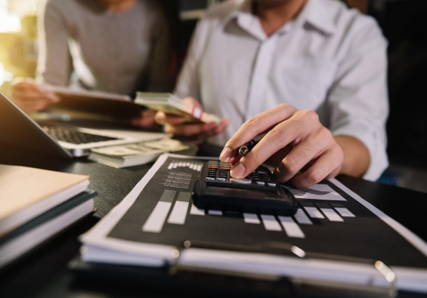 Pessoa usando calculadora para analisar finanças antes de contratar empréstimo.