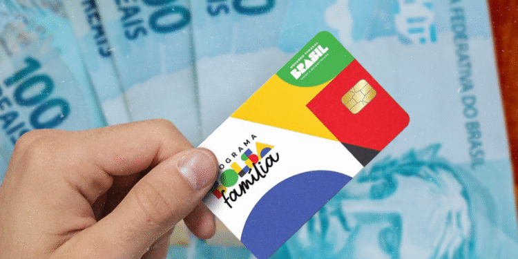 Cartão do Programa Bolsa Família com notas de 100 reais ao fundo.