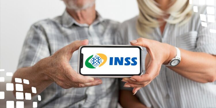 Imagem de casal idoso segurando um celular com o logo do INSS na tela, simbolizando o acesso a benefícios sociais.