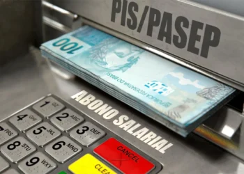 "Notas de R$100 saindo de um caixa eletrônico com a etiqueta PIS/PASEP."
