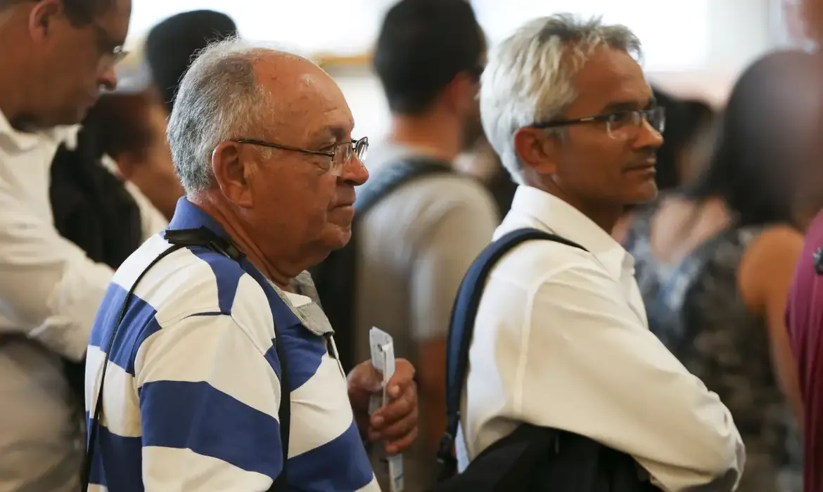 Idosos em fila aguardando atendimento em local público