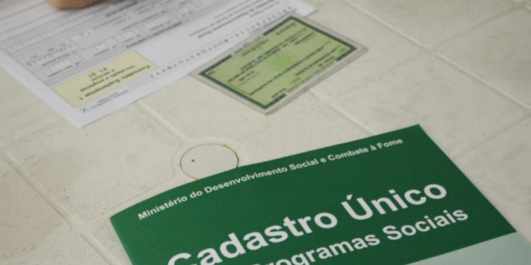 Imagem de uma pessoa preenchendo um formulário do Cadastro Único para Programas Sociais com um Cartão do Cadastro Único em cima da mesa. A ação está relacionada ao mutirão de atualização que ocorre até a próxima sexta-feira (27).