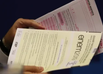 Prova do Enem sendo manuseada por aplicador do exame