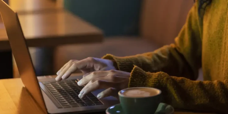 Pessoa utilizando notebook para efetuar pagamento online com diferentes formas disponíveis.
