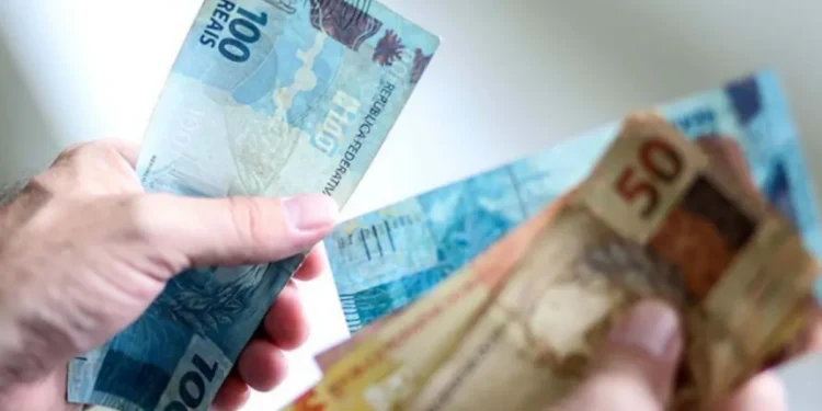 Pessoa segurando cédulas de reais, ilustrando dinheiro disponível para empréstimo consignado.