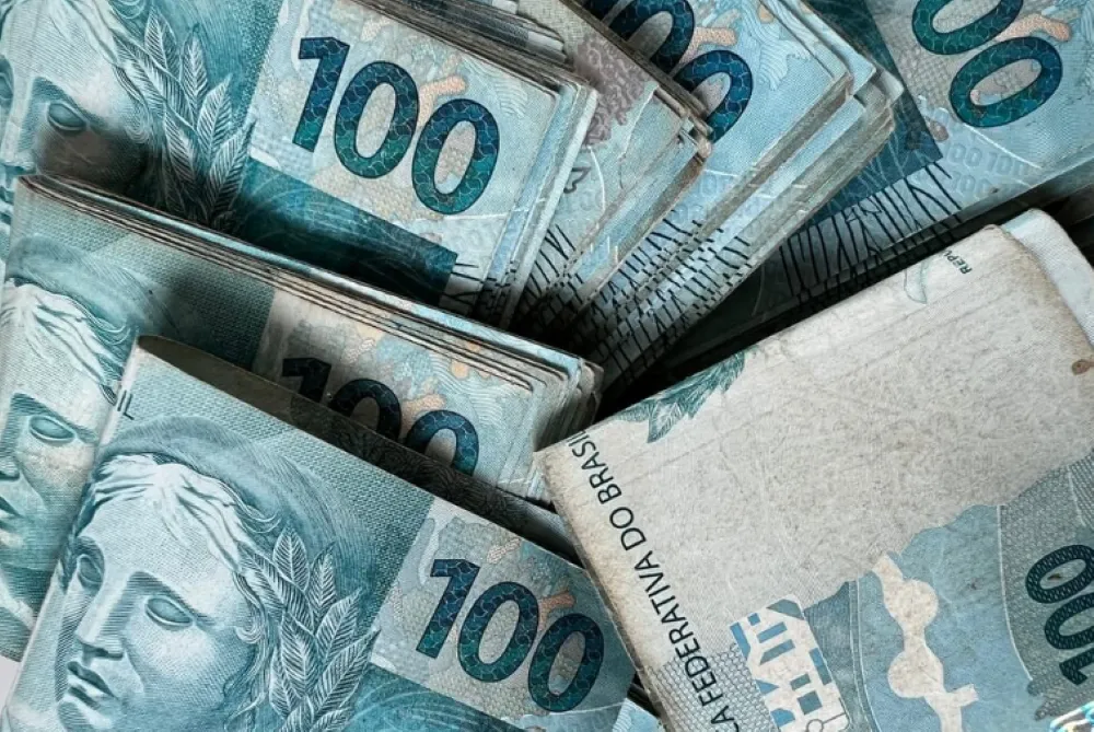 Cédulas de 100 reais representando o saque do FGTS em 2025