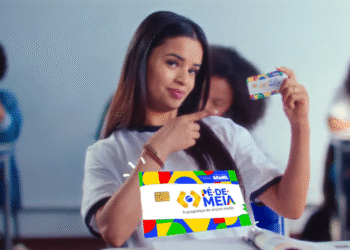Estudante exibindo o cartão do Pé de Meia, com sorriso confiante, em sala de aula.