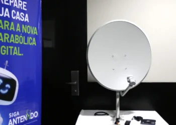 Equipamento de antena parabólica digital ao lado de banner informativo