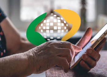 Idoso usando celular para verificar mensagem sobre restituição INSS de descontos indevidos.