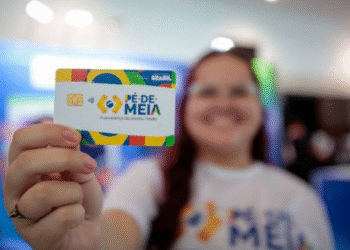 Mão segurando um cartão do programa Pé de Meia do governo brasileiro, com foco em apoio financeiro para estudantes em 2025