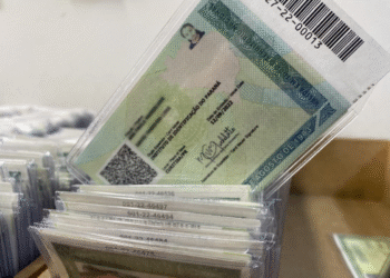 Mutirão do novo RG em Curitiba, Paraná, com pilha de documentos.