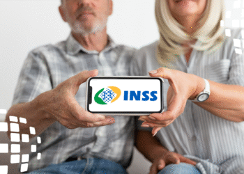 Casal idoso segurando um celular que exibe o logo do INSS.