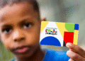 Bolsa Família: quem recebe pagamentos até a próxima sexta (22)? 4 Criança segurando cartão do Programa Bolsa Família