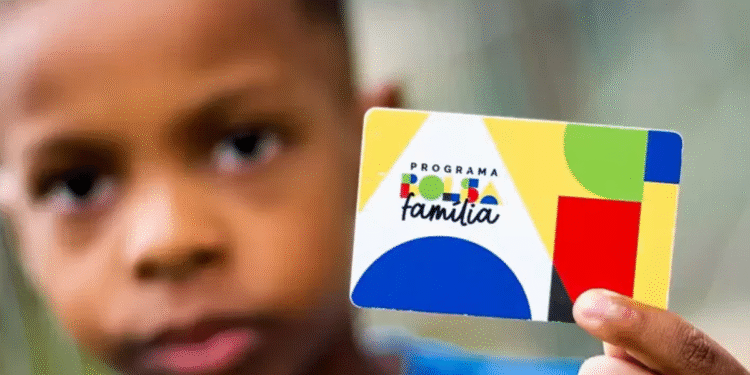 Criança segurando cartão do Programa Bolsa Família