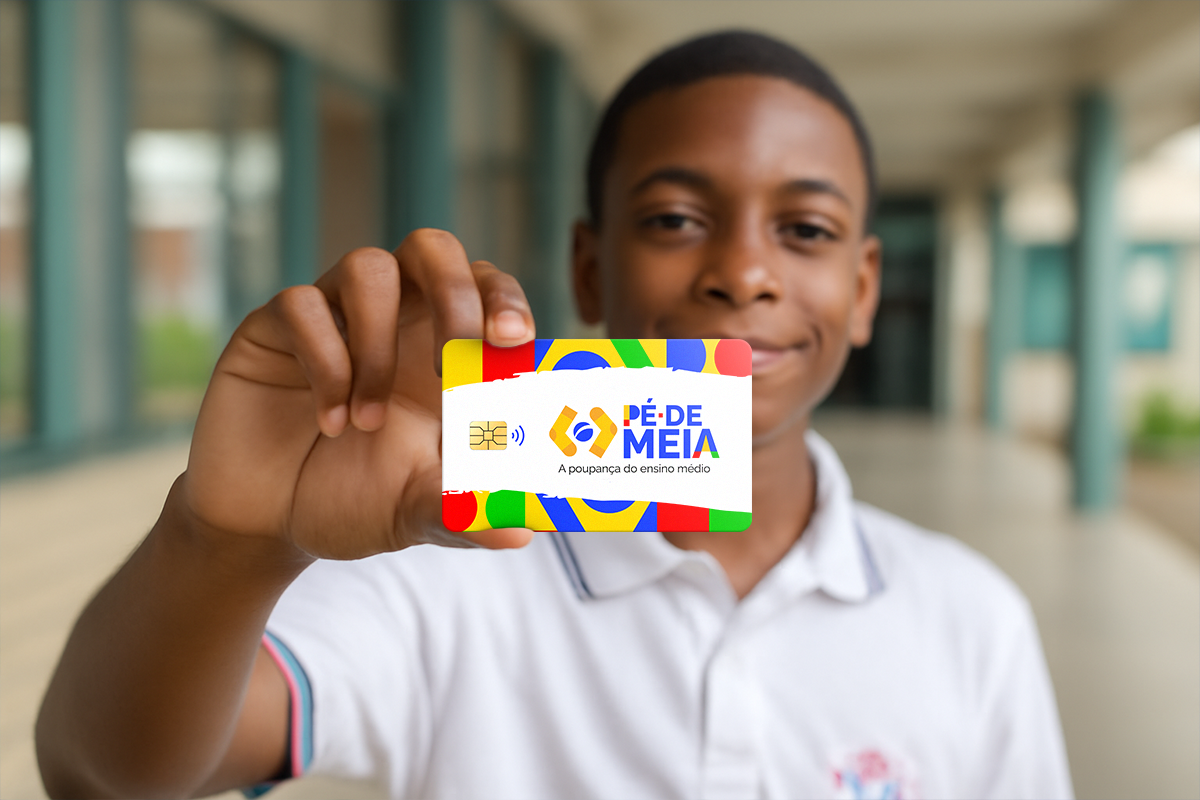 Jovem estudante negro sorrindo, segurando o cartão do programa Pé-de-Meia.