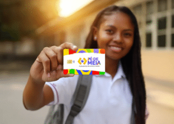 Estudante segurando o cartão do programa Pé-de-Meia, que incentiva a poupança no ensino médio.